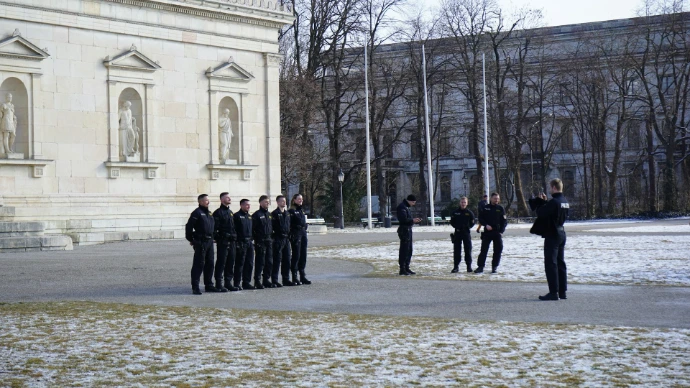 Soldiers are saluting outdoors near a building.